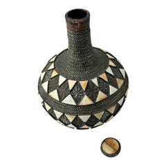 Vintage Moroccan pottery vase from the 1970s/80s, featuring a large clay body with ornate metal inlays, an antiqued bronze/brass finish, and three geometric rings of camel bone triangle patterns. Includes an original metal lid, reflecting its historic use for storing and transporting liquids. In very good vintage condition, showcasing intricate craftsmanship and cultural heritage.