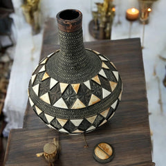 Vintage Moroccan pottery vase from the 1970s/80s, featuring a large clay body with ornate metal inlays, an antiqued bronze/brass finish, and three geometric rings of camel bone triangle patterns. Includes an original metal lid, reflecting its historic use for storing and transporting liquids. In very good vintage condition, showcasing intricate craftsmanship and cultural heritage.