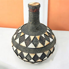 Vintage Moroccan pottery vase from the 1970s/80s, featuring a large clay body with ornate metal inlays, an antiqued bronze/brass finish, and three geometric rings of camel bone triangle patterns. Includes an original metal lid, reflecting its historic use for storing and transporting liquids. In very good vintage condition, showcasing intricate craftsmanship and cultural heritage.