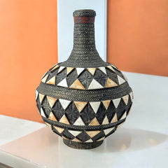 Vintage Moroccan pottery vase from the 1970s/80s, featuring a large clay body with ornate metal inlays, an antiqued bronze/brass finish, and three geometric rings of camel bone triangle patterns. Includes an original metal lid, reflecting its historic use for storing and transporting liquids. In very good vintage condition, showcasing intricate craftsmanship and cultural heritage.