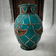 Vintage Moroccan round vase with green glaze, featuring geometric metal decor, four dyed leather inlays with yellow or red bezel-set glass cabochons at their center, and triangle-shaped leather accents around the top, from the 1970s/80s in very good condition.