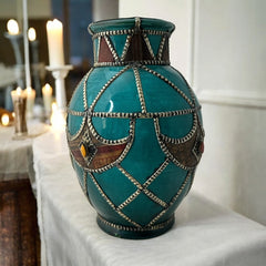 Vintage Moroccan round vase with green glaze, featuring geometric metal decor, four dyed leather inlays with yellow or red bezel-set glass cabochons at their center, and triangle-shaped leather accents around the top, from the 1970s/80s in very good condition.