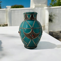Vintage Moroccan round vase with green glaze, featuring geometric metal decor, four dyed leather inlays with yellow or red bezel-set glass cabochons at their center, and triangle-shaped leather accents around the top, from the 1970s/80s in very good condition.