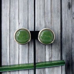 Vintage French button earrings featuring moss green marbled plastic cabochons set in silver tone borders. A classy and elegant 1970s design with retro charm, perfect for sustainable and eco-conscious fashion lovers.