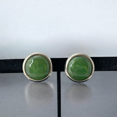 Vintage French button earrings featuring moss green marbled plastic cabochons set in silver tone borders. A classy and elegant 1970s design with retro charm, perfect for sustainable and eco-conscious fashion lovers.