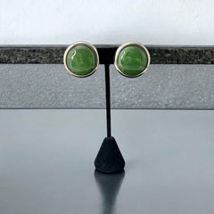 Vintage French button earrings featuring moss green marbled plastic cabochons set in silver tone borders. A classy and elegant 1970s design with retro charm, perfect for sustainable and eco-conscious fashion lovers.