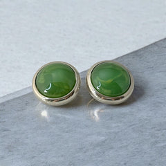 Vintage French button earrings featuring moss green marbled plastic cabochons set in silver tone borders. A classy and elegant 1970s design with retro charm, perfect for sustainable and eco-conscious fashion lovers.