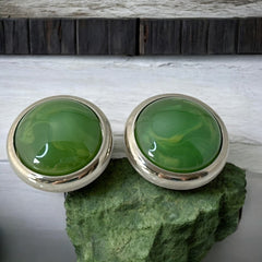 Vintage French button earrings featuring moss green marbled plastic cabochons set in silver tone borders. A classy and elegant 1970s design with retro charm, perfect for sustainable and eco-conscious fashion lovers.