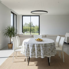 Round coated cotton tablecloth in white with polychrome and blue Provençal motifs, featuring birds, butterflies, and floral designs inspired by traditional Moustiers faience