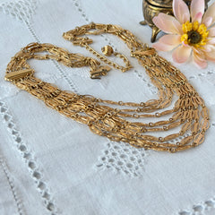 Vintage multi‑strand filigree gold‑tone bib necklace with ornate oval links and adjustable hook clasp.