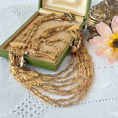 Vintage multi‑strand filigree gold‑tone bib necklace with ornate oval links and adjustable hook clasp.