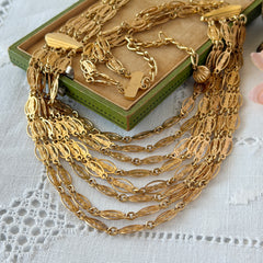 Vintage multi‑strand filigree gold‑tone bib necklace with ornate oval links and adjustable hook clasp.