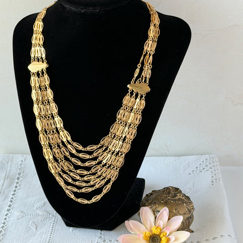 Vintage multi‑strand filigree gold‑tone bib necklace with ornate oval links and adjustable hook clasp.