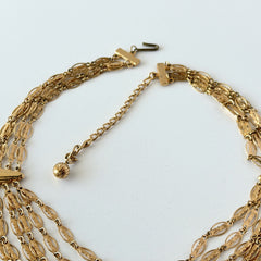 Vintage multi‑strand filigree gold‑tone bib necklace with ornate oval links and adjustable hook clasp.