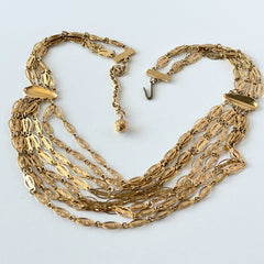Vintage multi‑strand filigree gold‑tone bib necklace with ornate oval links and adjustable hook clasp.