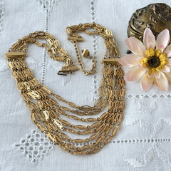 Vintage multi‑strand filigree gold‑tone bib necklace with ornate oval links and adjustable hook clasp.