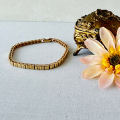 Vintage Napier gold‑tone cube link bracelet with articulated square links and signed fold‑over clasp.