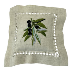 Ecru cotton sachet pillow embroidered with a branch of black olives and green leaves, framed by a lace-like hemstitch border. Filled with fragrant French lavender buds, this handmade cushion evokes rustic Mediterranean charm and artisanal elegance.