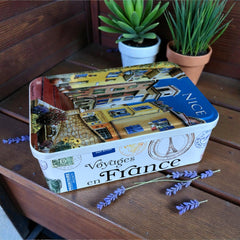 French holiday tin gift box with two mini Marseille soaps and a lavender sachet nestled in crinkle paper, available in Paris, Nice, or Côte d’Azur designs — a festive surprise gift from France.