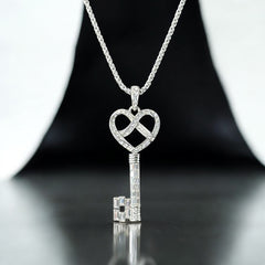 Vintage Nolan Miller silver-tone key pendant necklace with clear rhinestones in heart and infinity design, shown on twisted rope chain.