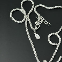 Vintage Nolan Miller silver-tone key pendant necklace with clear rhinestones in heart and infinity design, shown on twisted rope chain.