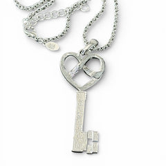 Vintage Nolan Miller silver-tone key pendant necklace with clear rhinestones in heart and infinity design, shown on twisted rope chain.