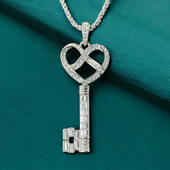 Vintage Nolan Miller silver-tone key pendant necklace with clear rhinestones in heart and infinity design, shown on twisted rope chain.