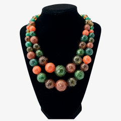 Vintage 1950s 2-strand graduated necklace featuring transparent and opaque orange and green plastic beads, finished with gold-tone findings and an adjustable hook clasp, in very good vintage condition.