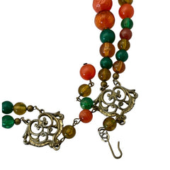 Vintage 1950s 2-strand graduated necklace featuring transparent and opaque orange and green plastic beads, finished with gold-tone findings and an adjustable hook clasp, in very good vintage condition.
