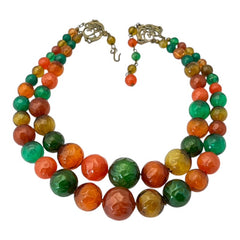 Vintage 1950s 2-strand graduated necklace featuring transparent and opaque orange and green plastic beads, finished with gold-tone findings and an adjustable hook clasp, in very good vintage condition.
