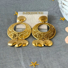 Vintage 1980s gold‑tone circle dangle post earrings with embossed paisley design and dangling discs, displayed on original Impressions card.