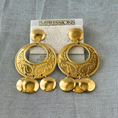 Vintage 1980s gold‑tone circle dangle post earrings with embossed paisley design and dangling discs, displayed on original Impressions card.
