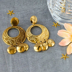Vintage 1980s gold‑tone circle dangle post earrings with embossed paisley design and dangling discs, displayed on original Impressions card.
