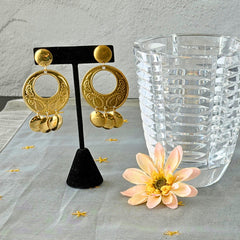 Vintage 1980s gold‑tone circle dangle post earrings with embossed paisley design and dangling discs, displayed on original Impressions card.