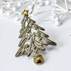 Vintage Paquette Christmas tree brooch in silver and gold-tone metal, featuring a modernist design with circular cutouts and a gold star at the top; signed on the back, circa 1990s, in very good condition.