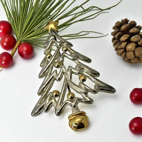 Vintage Paquette Christmas tree brooch in silver and gold-tone metal, featuring a modernist design with circular cutouts and a gold star at the top; signed on the back, circa 1990s, in very good condition.