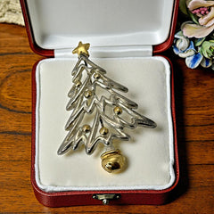 Vintage Paquette Christmas tree brooch in silver and gold-tone metal, featuring a modernist design with circular cutouts and a gold star at the top; signed on the back, circa 1990s, in very good condition.