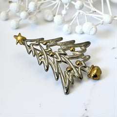 Vintage Paquette Christmas tree brooch in silver and gold-tone metal, featuring a modernist design with circular cutouts and a gold star at the top; signed on the back, circa 1990s, in very good condition.
