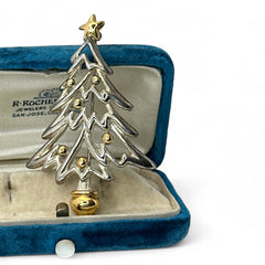 Vintage Paquette Christmas tree brooch in silver and gold-tone metal, featuring a modernist design with circular cutouts and a gold star at the top; signed on the back, circa 1990s, in very good condition.