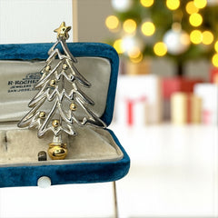 Vintage Paquette Christmas tree brooch in silver and gold-tone metal, featuring a modernist design with circular cutouts and a gold star at the top; signed on the back, circa 1990s, in very good condition.