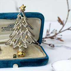 Vintage Paquette Christmas tree brooch in silver and gold-tone metal, featuring a modernist design with circular cutouts and a gold star at the top; signed on the back, circa 1990s, in very good condition.