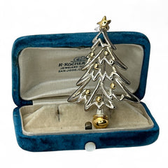 Vintage Paquette Christmas tree brooch in silver and gold-tone metal, featuring a modernist design with circular cutouts and a gold star at the top; signed on the back, circa 1990s, in very good condition.