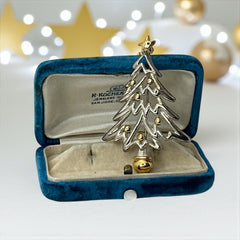 Vintage Paquette Christmas tree brooch in silver and gold-tone metal, featuring a modernist design with circular cutouts and a gold star at the top; signed on the back, circa 1990s, in very good condition.