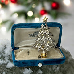 Vintage Paquette Christmas tree brooch in silver and gold-tone metal, featuring a modernist design with circular cutouts and a gold star at the top; signed on the back, circa 1990s, in very good condition.