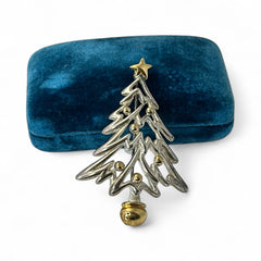 Vintage Paquette Christmas tree brooch in silver and gold-tone metal, featuring a modernist design with circular cutouts and a gold star at the top; signed on the back, circa 1990s, in very good condition.