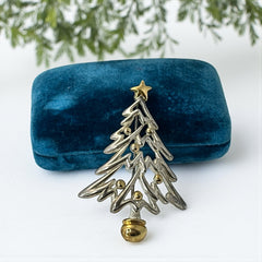 Vintage Paquette Christmas tree brooch in silver and gold-tone metal, featuring a modernist design with circular cutouts and a gold star at the top; signed on the back, circa 1990s, in very good condition.