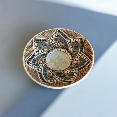 Vintage French studio pottery small dish by Paul Dordet, crafted in the 1950s-1960s. Features a round shape with a light blue enamel star design on buff and terracotta-colored clay. Signed 'Dordet' and in excellent vintage condition, this collectible piece showcases sustainable craftsmanship and timeless artistry.