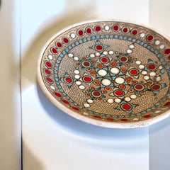Vintage French studio pottery bowl by Paul Dordet, hand-formed in textured buff clay with red, white, and blue glazed circular motifs; signed on the underside and shown with hanging wire for optional wall display.