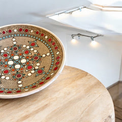 Vintage French studio pottery bowl by Paul Dordet, hand-formed in textured buff clay with red, white, and blue glazed circular motifs; signed on the underside and shown with hanging wire for optional wall display.