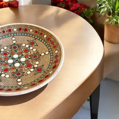 Vintage French studio pottery bowl by Paul Dordet, hand-formed in textured buff clay with red, white, and blue glazed circular motifs; signed on the underside and shown with hanging wire for optional wall display.